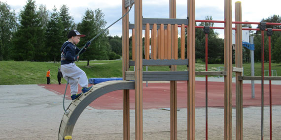 Kuva lapsi kiipeää leikkikentän kiipeilytelineeseen